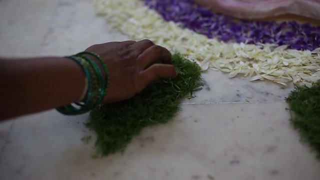 A girl decorating with the help of flower petals