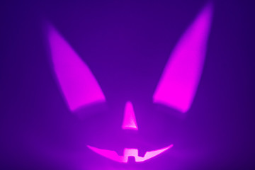 Halloween scary face on violet background. Scary smile face. Holiday horror background