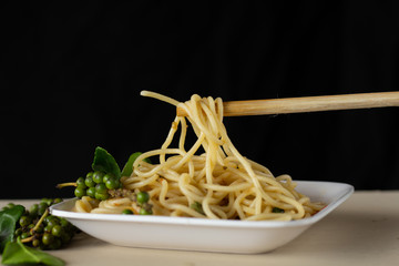 Spaghetti lines on chopsticks with black background,