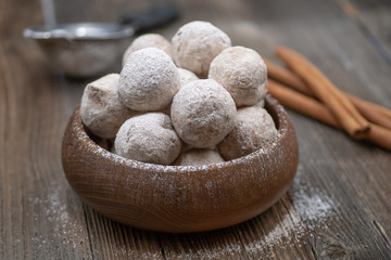 Wooden bowl with apple and spice donut holes, sprinkled with cinnamon sugar