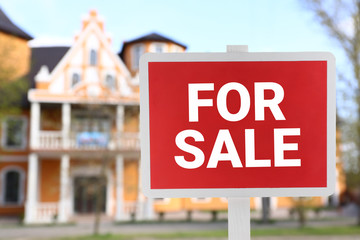 Obraz premium Sign board with text FOR SALE near modern building on city street