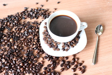 cup of coffee and beans on wooden table