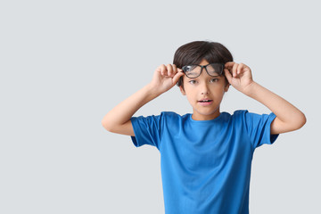 Surprised little boy on light background