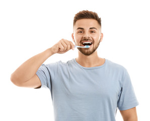 Portrait of man brushing teeth on white background