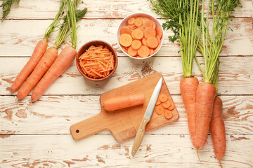 Fresh carrot with cutting board and knife on wooden background