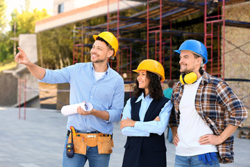 Architects discussing project of building outdoors