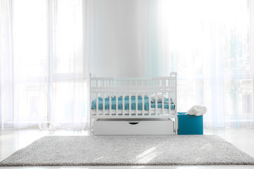 Stylish baby bed in interior of children's room