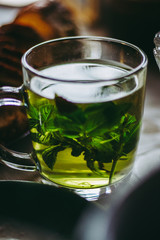 Warm herbal green mint tea in a glass cup