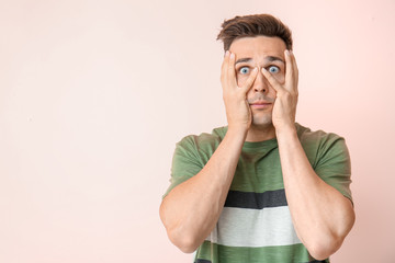 Shocked young man on color background
