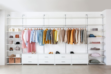 Big wardrobe with clothes in dressing room