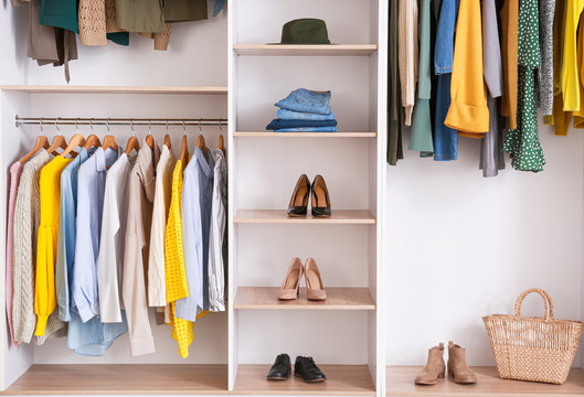 Big wardrobe with clothes in dressing room