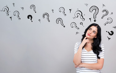 Question marks with young woman in a thoughtful face