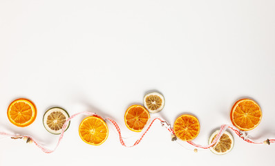 Christmas composition with dried oranges slices on white background. Natural dry food ingredient for cooking or Christmas decor for home. Flat lay.