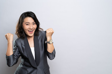 Happy woman make winning gesture isolated over white background