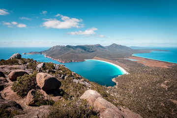 View from Mount Amos to the spectacular Wineglass Bay, white sandy beach and turquoise blue water, Freycinet National Park, Coles Bay, Tasmania, Australia