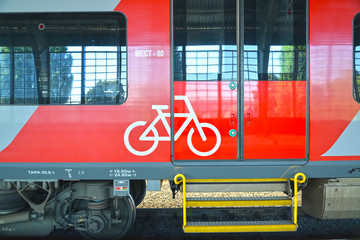 Obraz premium Entrance to electric train car for passengers with bicycles. Russian text - 80 seats