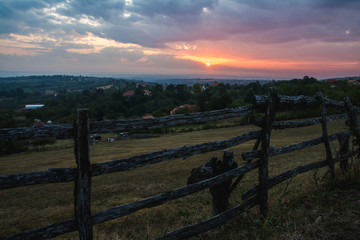 Obraz premium Sun is rising behind the clouds above hills of Serbia rural landscape region 