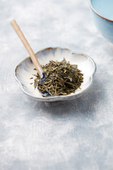 Dried Green Tea Leaves on Bright Background. Close up. Copy space. 