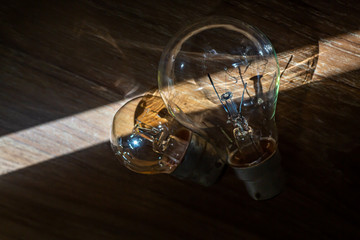 Two light bulbs on wood texture background, Light and Shadow, Close up and macro shot