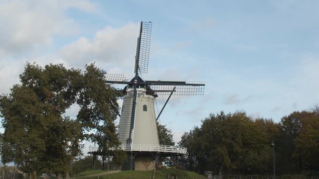 Tilting down from blue sky to beautiful traditional windmill - medium shot