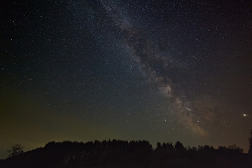 Stars of the milky way galaxy in the night sky. Space objects over the forest.
