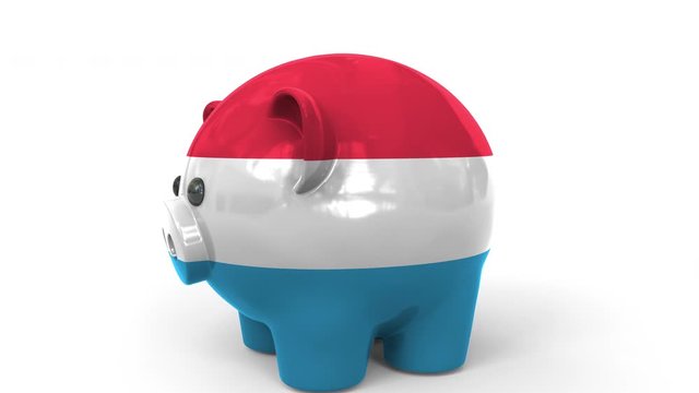 Coins fall into piggy bank painted with flag of Luxembourg. National banking system or savings related conceptual 3D animation