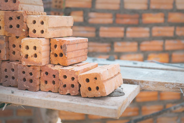 red bricks used for construction on brick wall background.