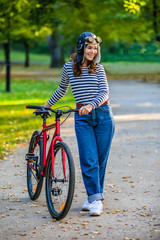 Woman standing with bike in city park