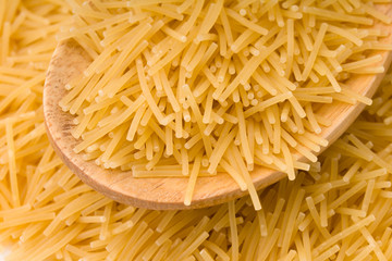 Wooden cooking spoons filled with noodle 