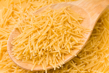 Wooden cooking spoons filled with noodle 