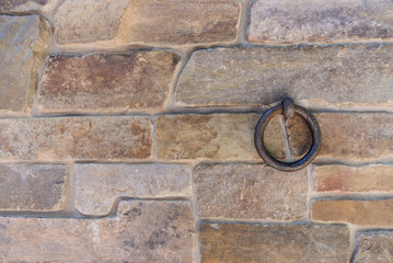 old rusty ring fixed in stone brick wall, holding and torturing hostage, horizontal stock photo...