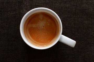 duftender frischer kaffee weiße porzellan tasse auf brauner leinen tischdecke 