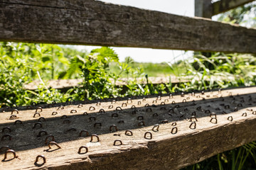 Metal hooks seen nailed into a public fence step, to help aid grip when the surface is wet.