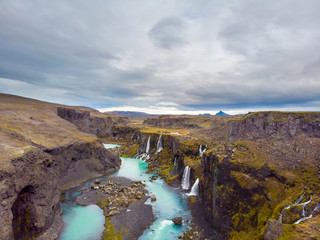 Scenic landscape view of incredible Sigoldugljufur canyon in highlands with turquoise river, Iceland. Volcanic landscape on background. Popular tourist attraction..