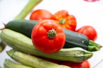 Fototapeta na wymiar fresh vegetables in the foreground, zucchini tomatoes and cucumbers
