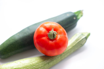 fresh vegetables in the foreground, zucchini tomatoes and cucumbers
