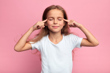 cheerful attractive girl touchig her temples, massaging her head, kid trying to remember some information, close up portrait, isolated pink background, studio shot. meditation concept. - 298648215