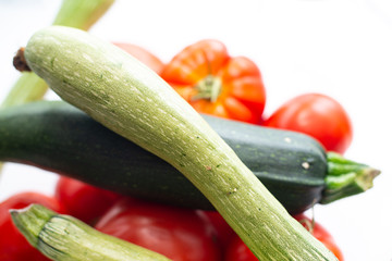 fresh vegetables in the foreground, zucchini tomatoes and cucumbers