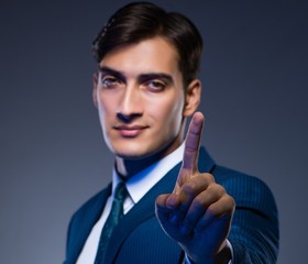 Businessman pressing virtual buttons on gray background