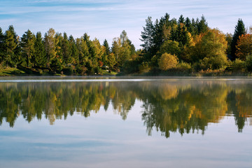 Fototapeta na wymiar Lake Bibi (Bibisee) in Bavaria in autumn with reflexions of multi coloured trees on the water surface