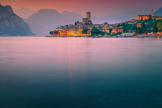 Popular Malcesine tourist resort at colorful sunset, Garda lake, Italy