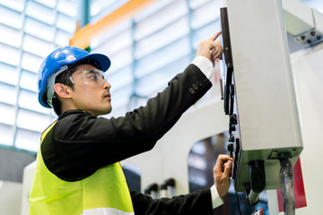 Asian Industrial Engineer in Safety hardhat check and control welding robotics automatic arms machine in intelligent factory High Quality Plastic mold industrial with monitoring system software.