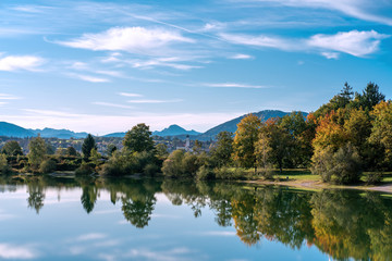 The village and church of Koenigsdorf in Bavaria with the Bibi Lake in the foreground and the mountains in the background