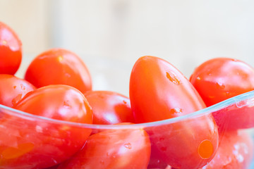 Close up fresh cherry tomato in wooden spoon on wood background.