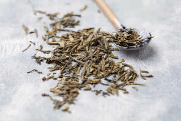 Dried Green Tea Leaves on Bright Background. Close up. 