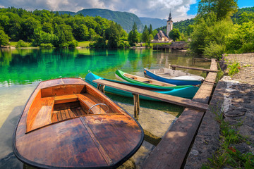 Spectacular alpine lake and colorful canoes, Lake Bohinj, Slovenia, Europe