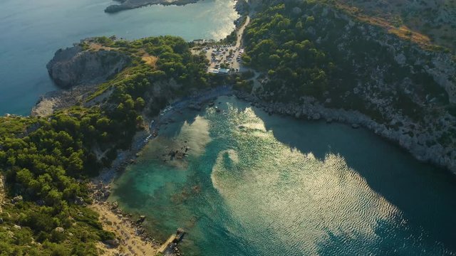 Aerial bird's eye view video taken by drone of famous beach of Anthony Quinn with clear water rocky seascape, Rhodes island, Greece.