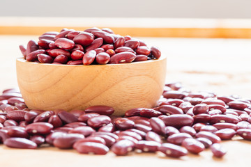 Red bean in wood bowl on wooden background. Healthy food with adzuki seeds...