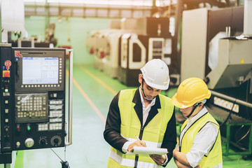 Male and Female Industrial Engineers in Safety helmet Discuss New Project Or check Order, product...