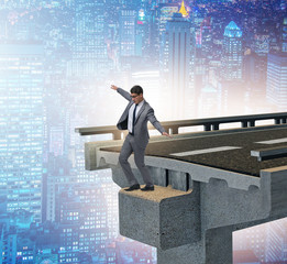 Businessman in uncertainty concept with broken bridge